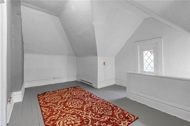 3014 Versailles Ave, Mckeesport, PA 15132 - bonus room featuring vaulted ceiling, a textured ceiling, a baseboard radiator, baseboards, and wood finished floors