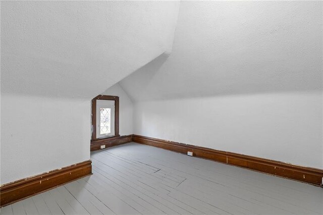 3014 Versailles Ave, Mckeesport, PA 15132 - bonus room featuring vaulted ceiling, baseboards, a textured ceiling, and wood finished floors