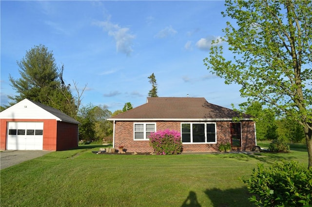 view of home's exterior featuring an outbuilding, a detached garage, a lawn, and brick siding