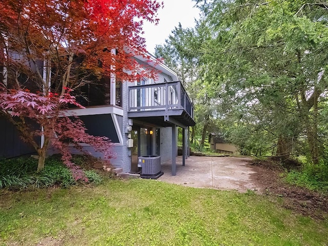 back of house featuring central AC unit, a yard, a patio, and a deck