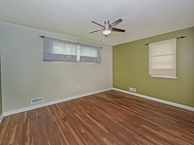 unfurnished room with wood finished floors, baseboards, and ceiling fan
