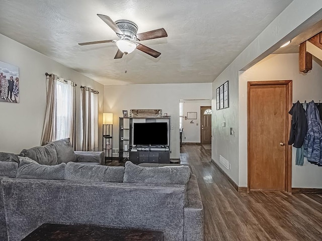 living room with a ceiling fan, dark wood finished floors, and baseboards