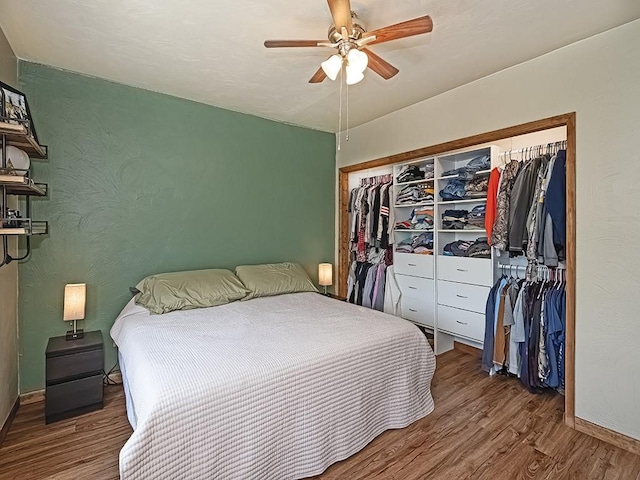 bedroom with wood finished floors, baseboards, a closet, and ceiling fan