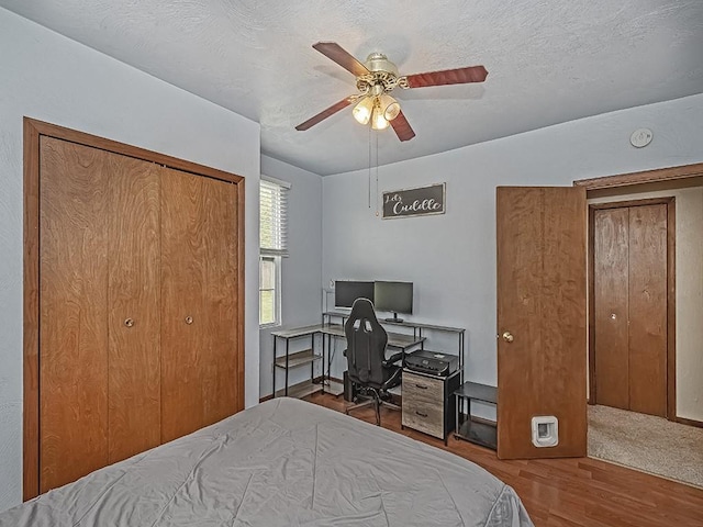 bedroom with a desk, wood finished floors, a closet, and a ceiling fan