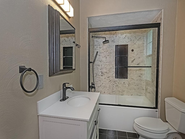 full bath featuring toilet, vanity, bath / shower combo with glass door, and tile patterned floors