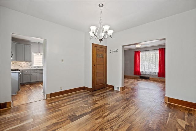 716 Center Ave N, Charleroi, PA 15022 - unfurnished dining area featuring healthy amount of natural light, wood finished floors, a chandelier, and baseboards