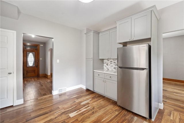 716 Center Ave N, Charleroi, PA 15022 - kitchen with freestanding refrigerator, arched walkways, decorative backsplash, light wood-style flooring, and baseboards