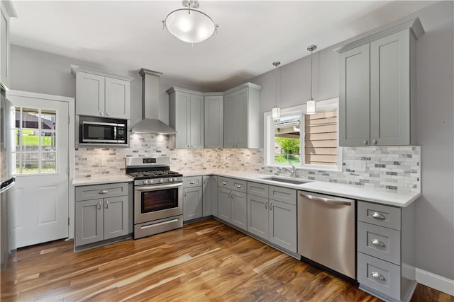 716 Center Ave N, Charleroi, PA 15022 - kitchen featuring stainless steel appliances, gray cabinetry, wall chimney exhaust hood, a sink, and light countertops
