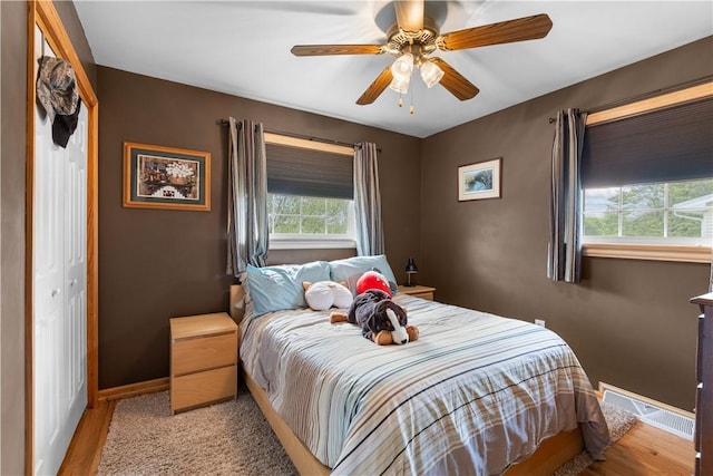 bedroom with baseboards, light wood-style floors, and a ceiling fan