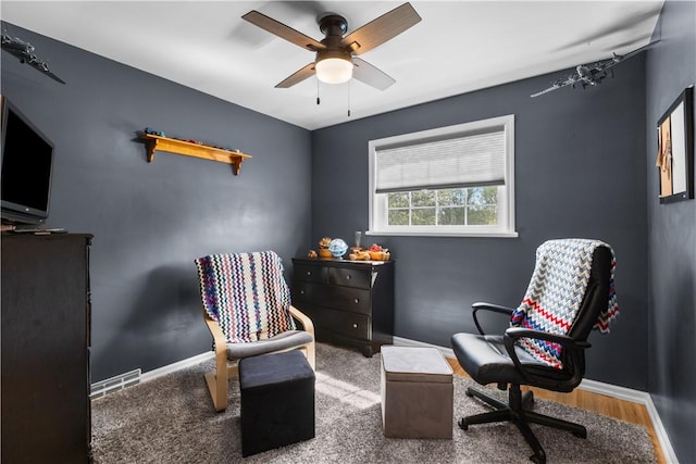 sitting room featuring a ceiling fan and baseboards