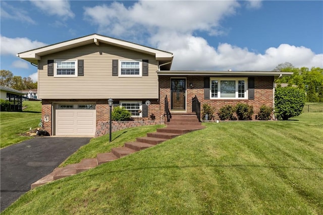 split level home featuring brick siding, a garage, driveway, and a front lawn