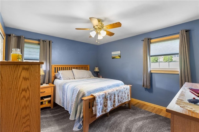 bedroom with ceiling fan, baseboards, and wood finished floors