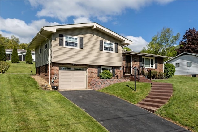 tri-level home with driveway, a garage, brick siding, and a front yard
