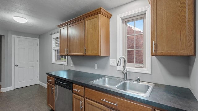172 Orchard Dr, Pleasant Hills, PA 15236 - kitchen featuring stainless steel dishwasher, a sink, dark countertops, brown cabinets, and baseboards
