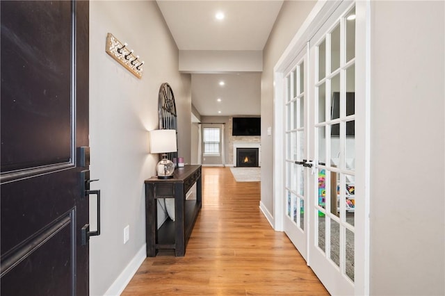 hall featuring light wood-type flooring, baseboards, and recessed lighting