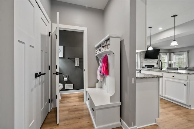 mudroom featuring light wood-type flooring, a sink, baseboards, and recessed lighting