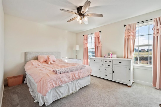 bedroom featuring light carpet, multiple windows, and ceiling fan