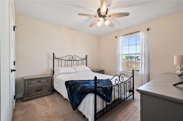 bedroom with light colored carpet, a ceiling fan, and baseboards