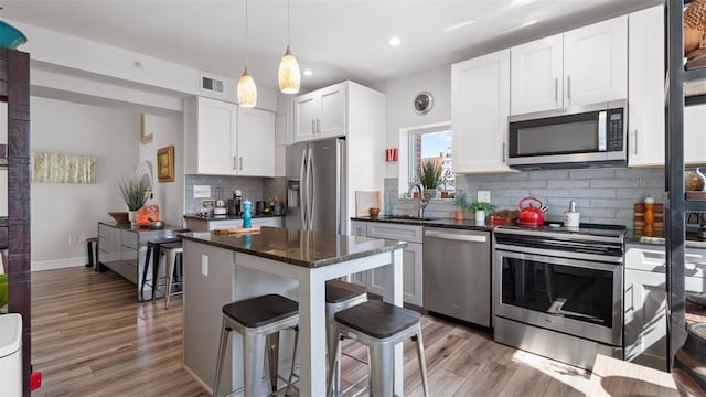 2132 Sarah St Unit 201, South Side, PA 15203 - kitchen featuring appliances with stainless steel finishes, a sink, light wood-style floors, recessed lighting, and backsplash