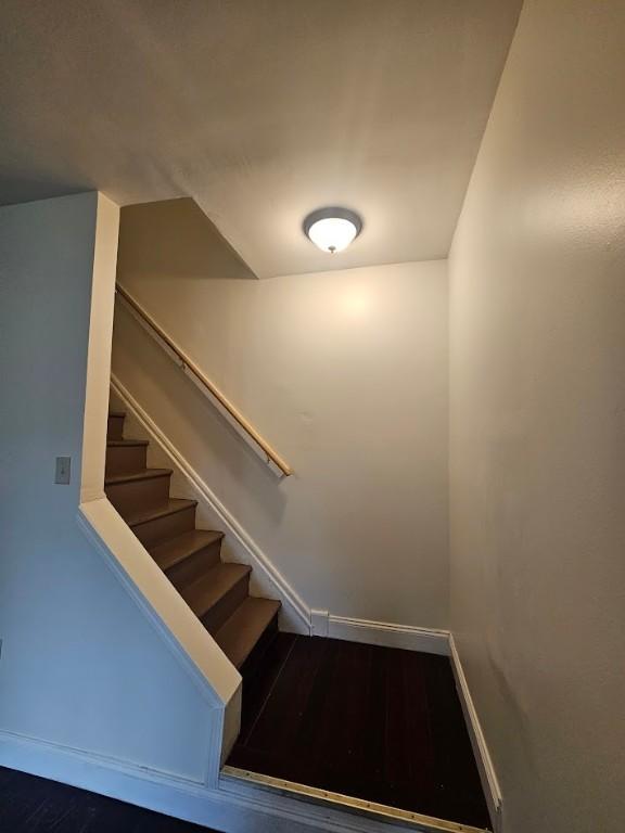 stairway with baseboards and wood finished floors
