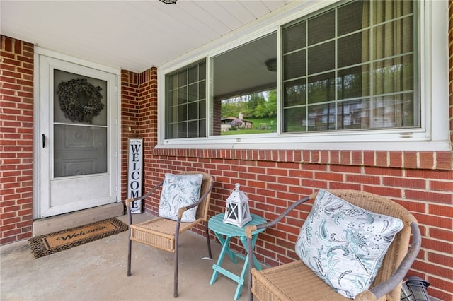 property entrance featuring brick siding and a porch