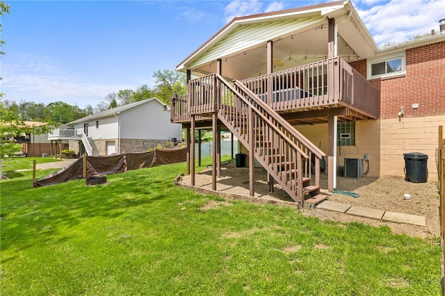 back of property with stairs, a wooden deck, central AC, and a yard