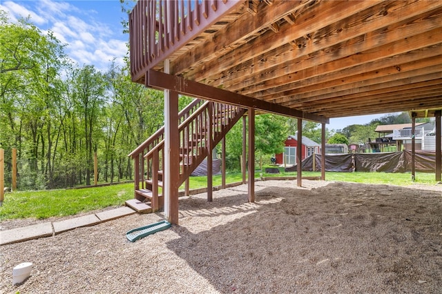 view of green lawn featuring stairs, an outdoor structure, and a storage unit