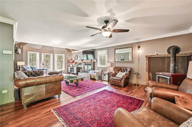 9935 Greiser Rd, Conneaut Lake Cra, PA 16316 - living area with a wood stove, a ceiling fan, baseboards, wood finished floors, and crown molding