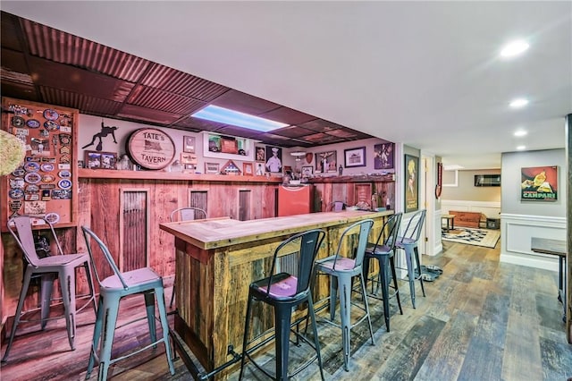 9935 Greiser Rd, Conneaut Lake Cra, PA 16316 - indoor bar with wood finished floors, wainscoting, recessed lighting, and a decorative wall