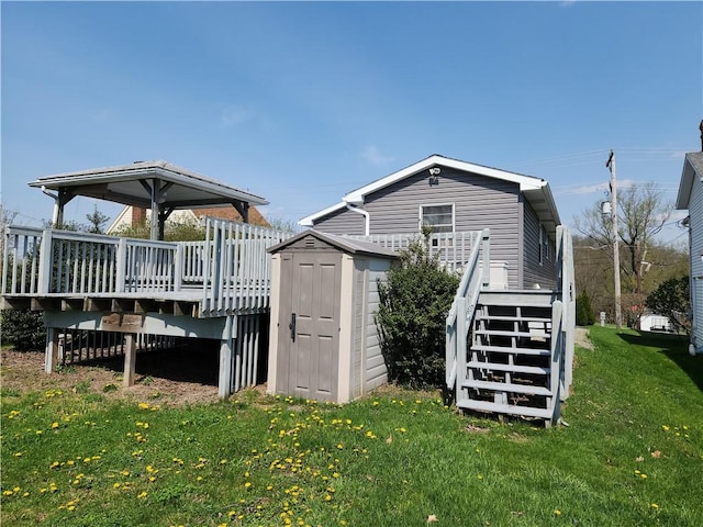 807 W 1st Ave, Derry Twp, PA 15627 - back of house with stairs, a shed, a wooden deck, a lawn, and an outbuilding
