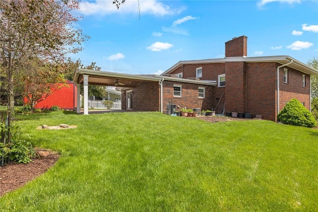 118 Tangelo Dr, Jefferson Hills, PA 15025 - rear view of house featuring a chimney, brick siding, a yard, and ceiling fan