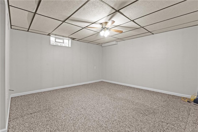 basement featuring carpet floors, a paneled ceiling, and baseboards