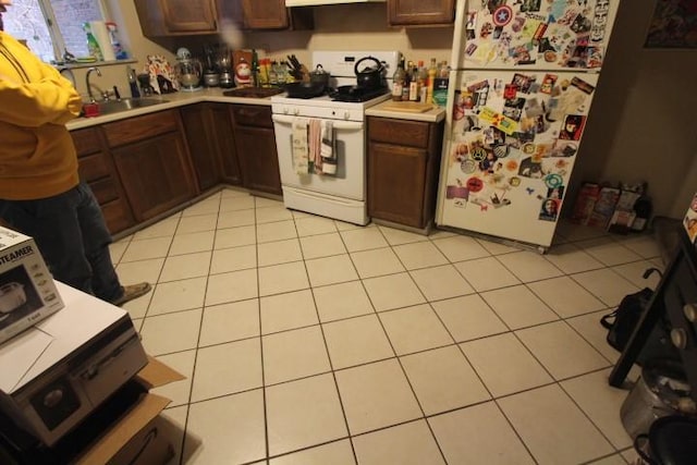 kitchen with white appliances, a sink, light countertops, and light tile patterned flooring