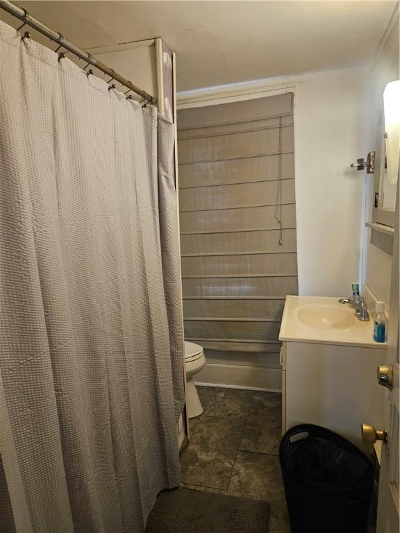 bathroom with toilet, vanity, and curtained shower