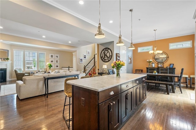 234 College Ave, Oakmont, PA 15139 - kitchen with a breakfast bar, dark wood finished floors, crown molding, a kitchen island, and a fireplace
