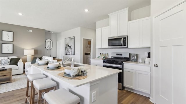 333 Gleneagles Dr, Center Twp But, PA 16001 - kitchen with stainless steel appliances, a sink, open floor plan, wood finished floors, and a center island with sink