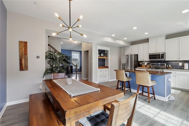 dining room with stairs, light wood-style flooring, baseboards, a chandelier, and recessed lighting