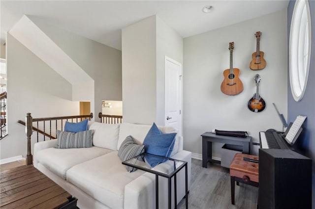 sitting room featuring wood finished floors, an upstairs landing, and baseboards