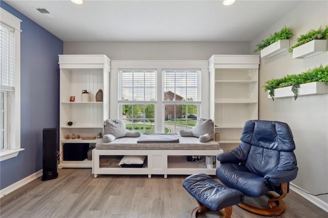 living area featuring healthy amount of natural light, wood finished floors, recessed lighting, and baseboards