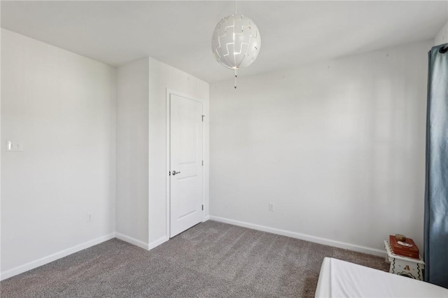 carpeted spare room featuring baseboards