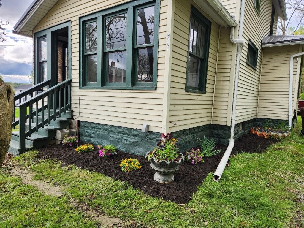 view of side of property with entry steps and metal roof