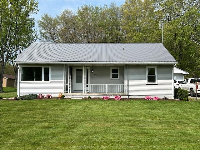 view of front of home with a porch, a front yard, and metal roof