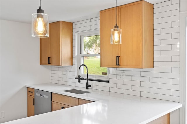 kitchen featuring dishwasher, a sink, decorative backsplash, light countertops, and hanging light fixtures