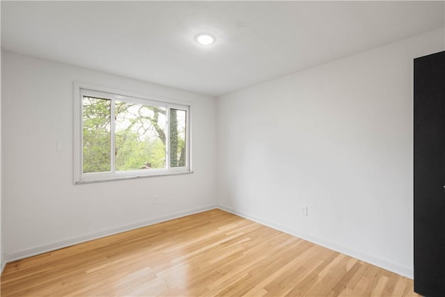 spare room featuring light wood-style floors and baseboards