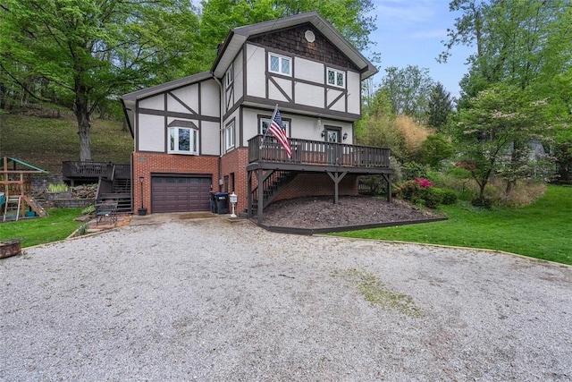 english style home with stairway, stucco siding, driveway, an attached garage, and a wooden deck