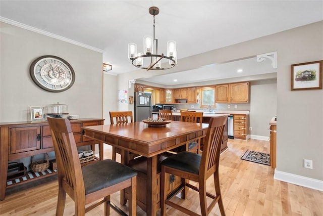 dining room featuring a chandelier, light wood finished floors, baseboards, recessed lighting, and crown molding