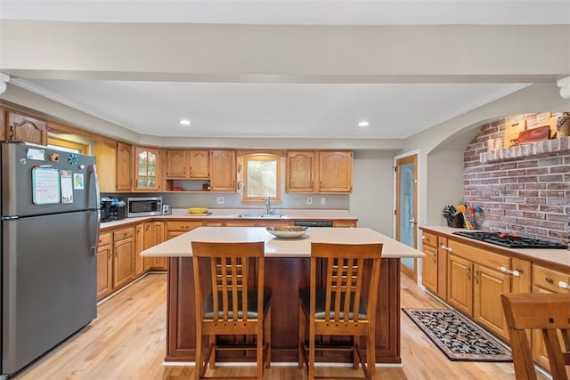 kitchen featuring stainless steel appliances, a sink, light wood-style floors, light countertops, and recessed lighting