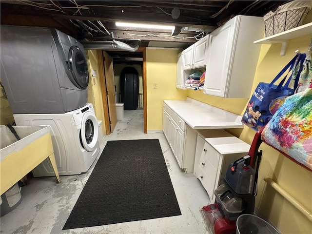 laundry room featuring estacked washer and dryer and cabinet space