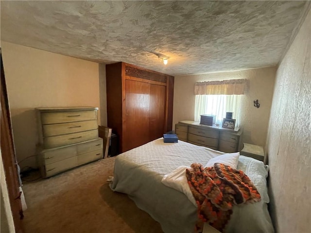 carpeted bedroom featuring a textured ceiling, a closet, and a textured wall