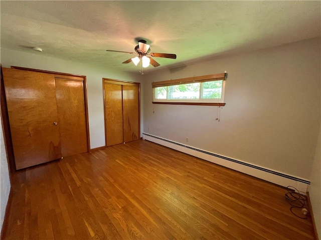 855 W Sanner St, Somerset Boro, PA 15501 - unfurnished bedroom featuring baseboard heating, wood finished floors, multiple closets, ceiling fan, and baseboards